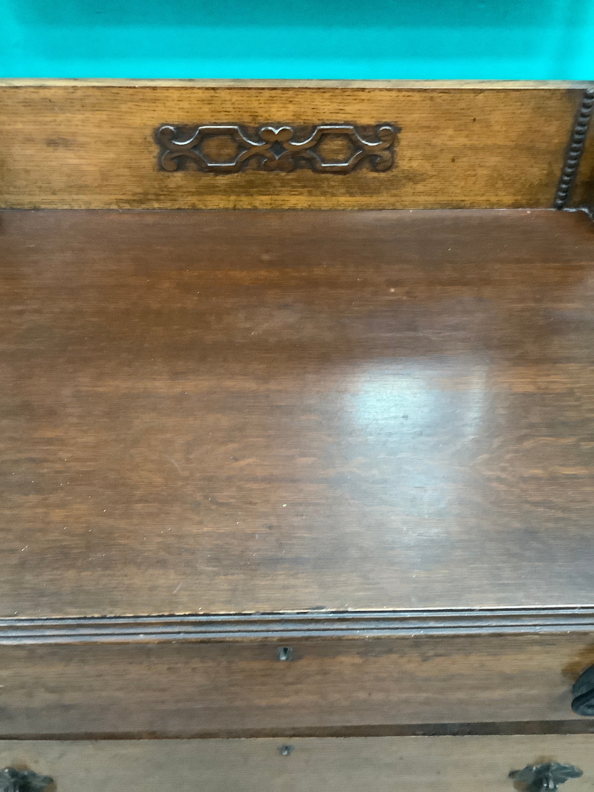 An antique Edwardian Arts & and Crafts dark oak dressing chest featuring a swing vanity mirror, decorative pierced metal drop handles, and a three-drawer configuration. 170826009