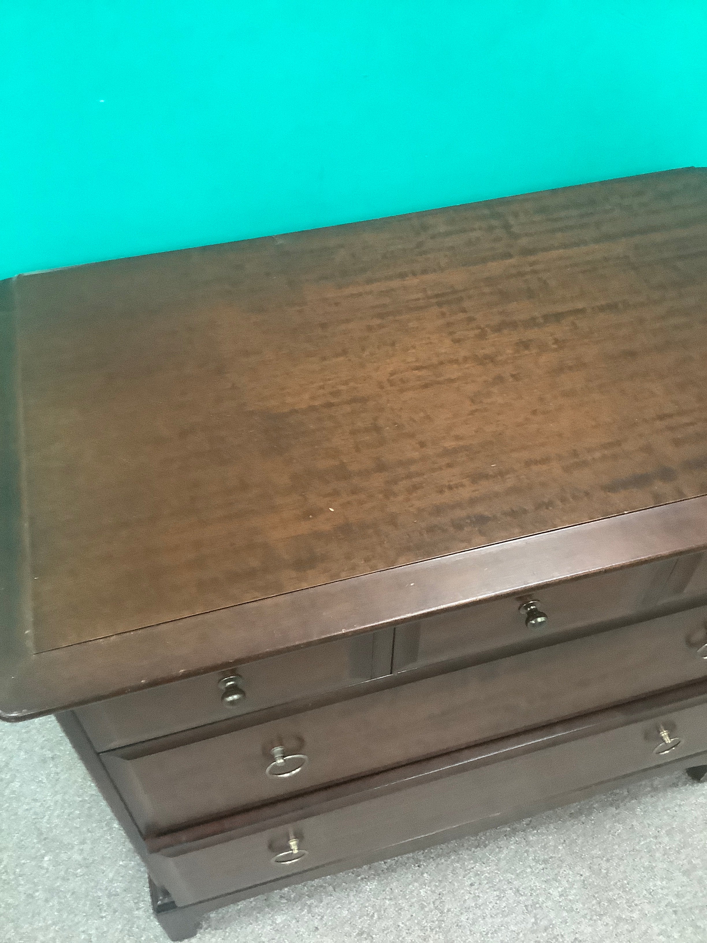 Stag Minstrel 3-over-2 chest of drawers, designed by John & Sylvia Reid in the mid-20th century and crafted from mahogany or cherry veneers with distinctive brass-toned ring pull handles. 190826003