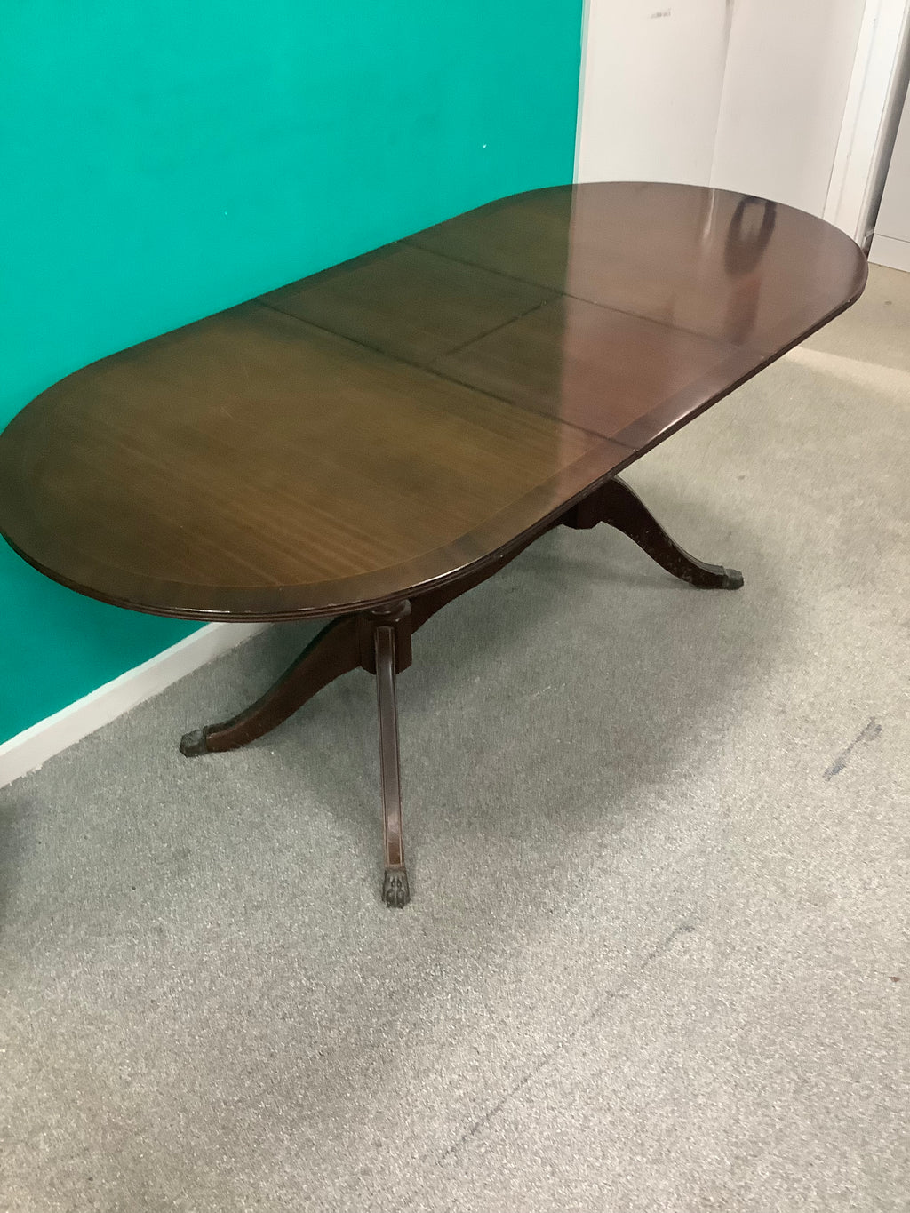 mahogany Regency-style double-pedestal extending dining table features an oval top and classic reeded saber legs with claw feet. 10826007