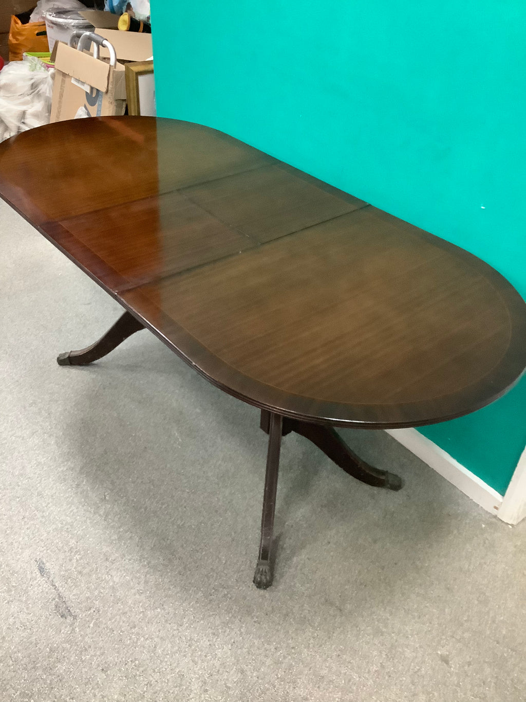 mahogany Regency-style double-pedestal extending dining table features an oval top and classic reeded saber legs with claw feet. 10826007