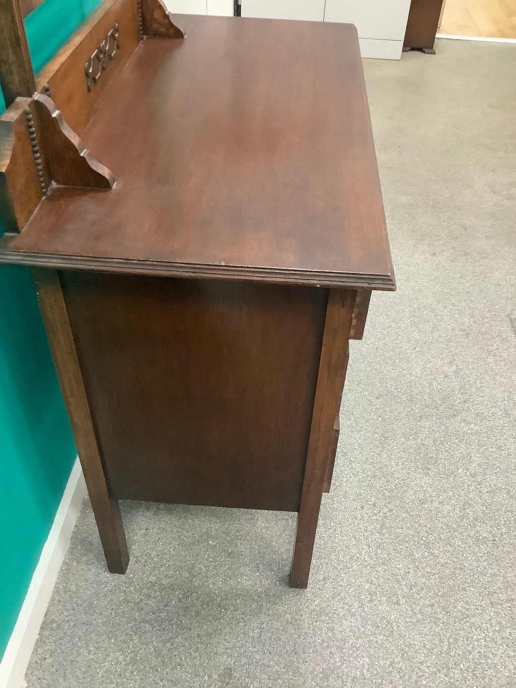 An antique Edwardian Arts & and Crafts dark oak dressing chest featuring a swing vanity mirror, decorative pierced metal drop handles, and a three-drawer configuration. 170826009