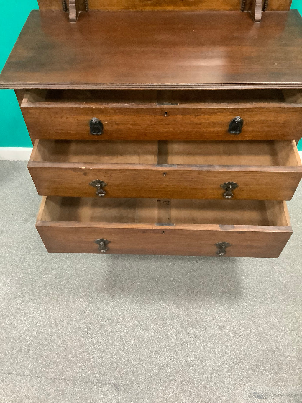 An antique Edwardian Arts & and Crafts dark oak dressing chest featuring a swing vanity mirror, decorative pierced metal drop handles, and a three-drawer configuration. 170826009