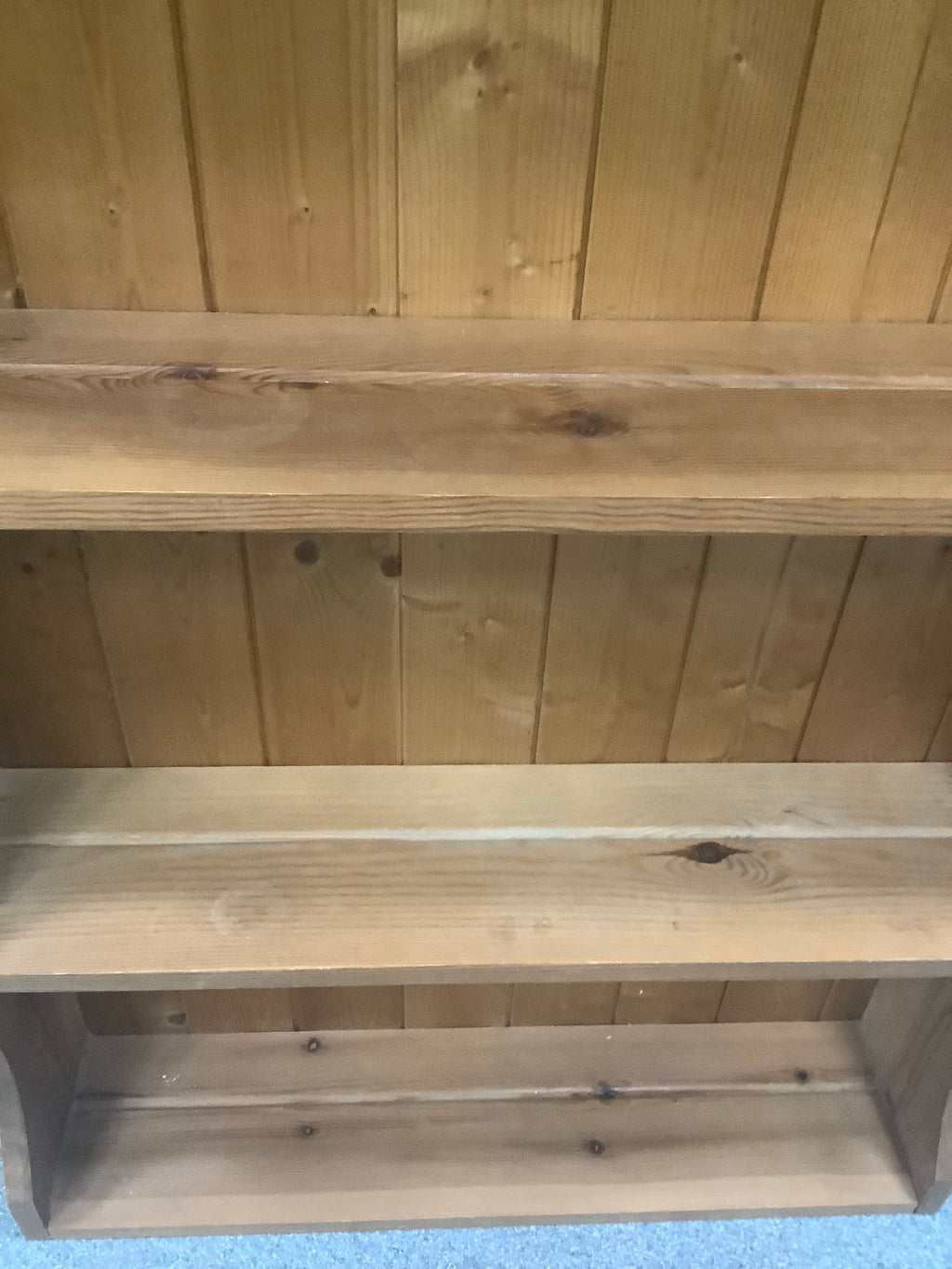 solid pine wall-hanging shelving unit or dresser top rack featuring a scalloped/arched crest rail and three fixed open shelves with a tongue-and-groove panel 190826001
