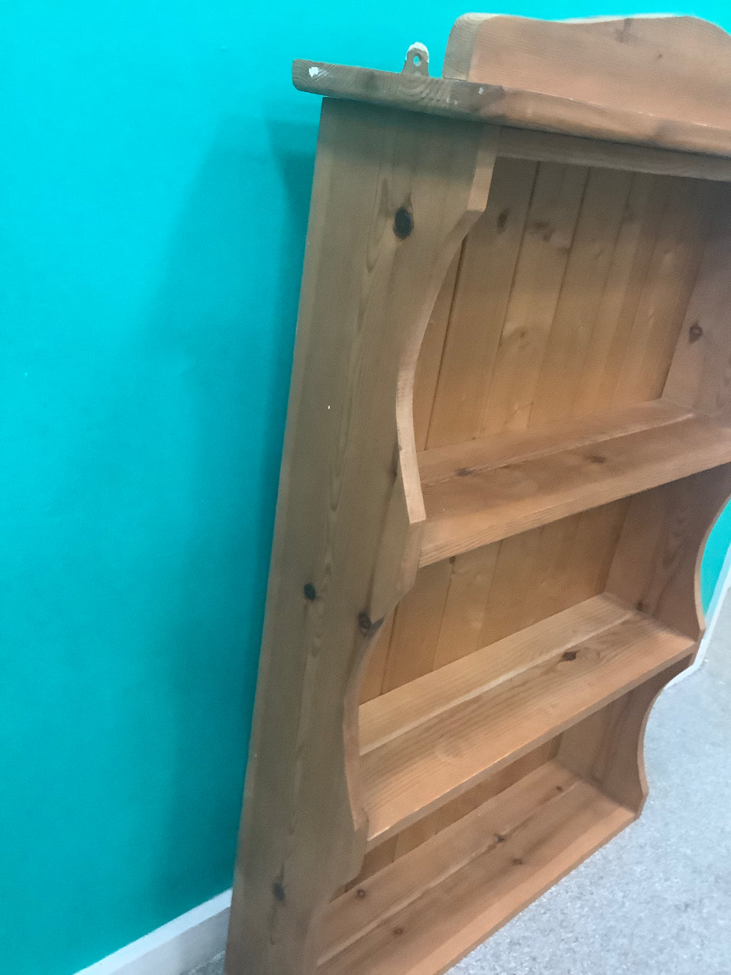 solid pine wall-hanging shelving unit or dresser top rack featuring a scalloped/arched crest rail and three fixed open shelves with a tongue-and-groove panel 190826001