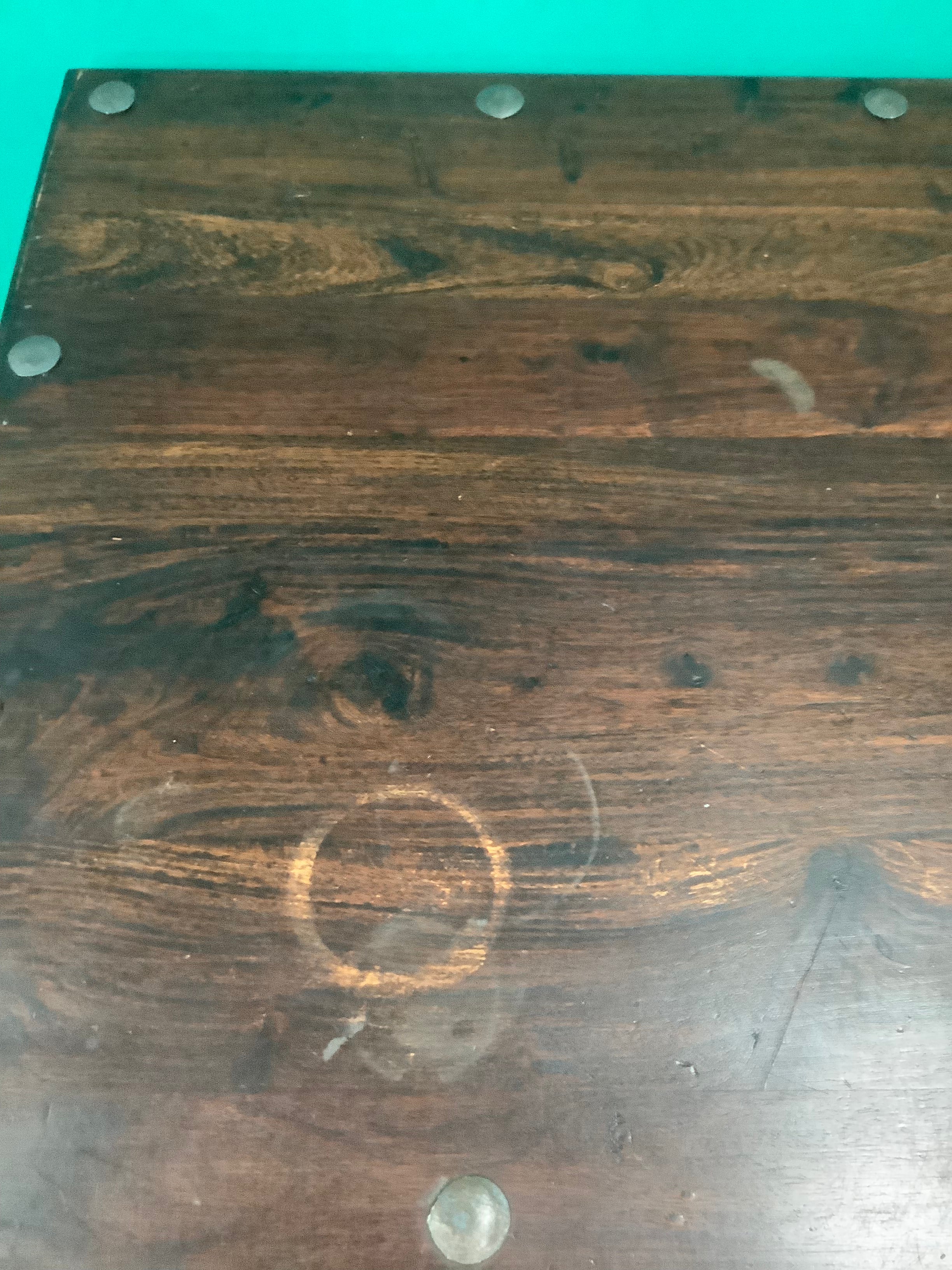 rustic dark solid wood coffee table features a rich stained top accented with decorative metal studs along the edge and turned bulbous legs. 210826002