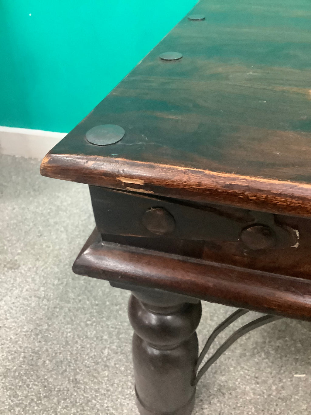 rustic dark solid wood coffee table features a rich stained top accented with decorative metal studs along the edge and turned bulbous legs. 210826002