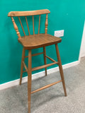 Windsor-style wooden bar stool features a spindle-back design with turned leg supports and multiple footrest stretchers for stability.210826004