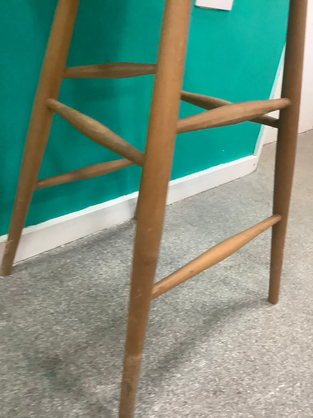 Windsor-style wooden bar stool features a spindle-back design with turned leg supports and multiple footrest stretchers for stability.210826004