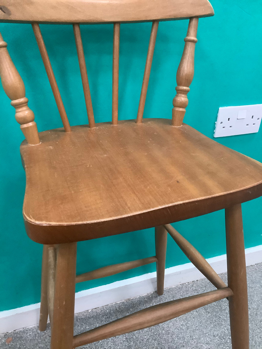 Windsor-style wooden bar stool features a spindle-back design with turned leg supports and multiple footrest stretchers for stability.210826004