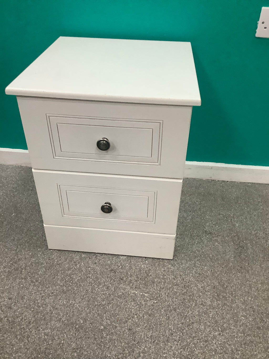 white 2-drawer bedside locker shown is a traditional freestanding nightstand featuring recessed drawer panels and round metal knobs. 210826006