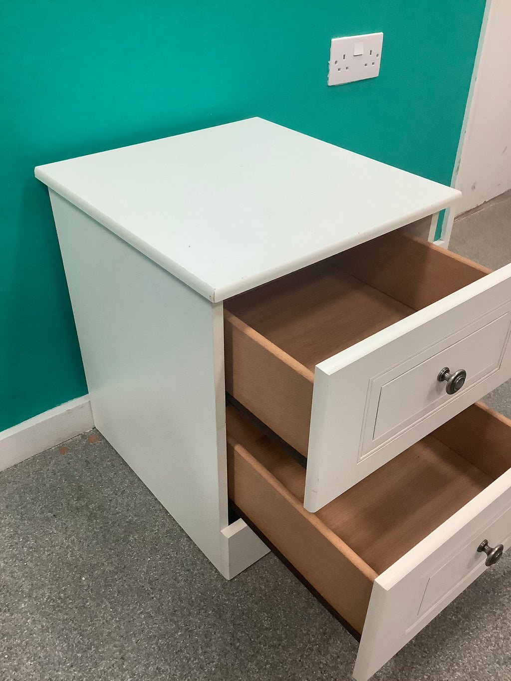 white 2-drawer bedside locker shown is a traditional freestanding nightstand featuring recessed drawer panels and round metal knobs. 210826006