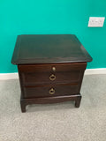 Stag Minstrel mahogany bedside cabinet featuring a pull-out sliding shelf above two drawers with distinctive brass-toned ring pulls. 240826001