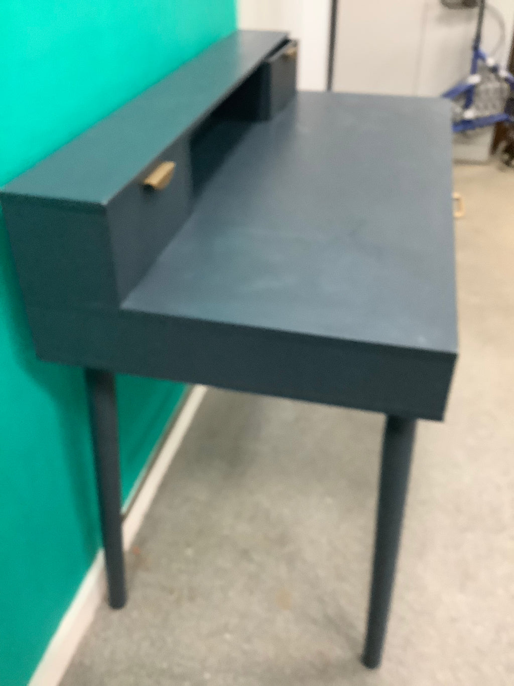 This is the dark blue or charcoal vintage-style "Penelope" 3-drawer desk by Maisons du Monde, featuring distinct brass-finish half-moon handle pulls and an elevated upper tier with integrated small compartments. 240826004
